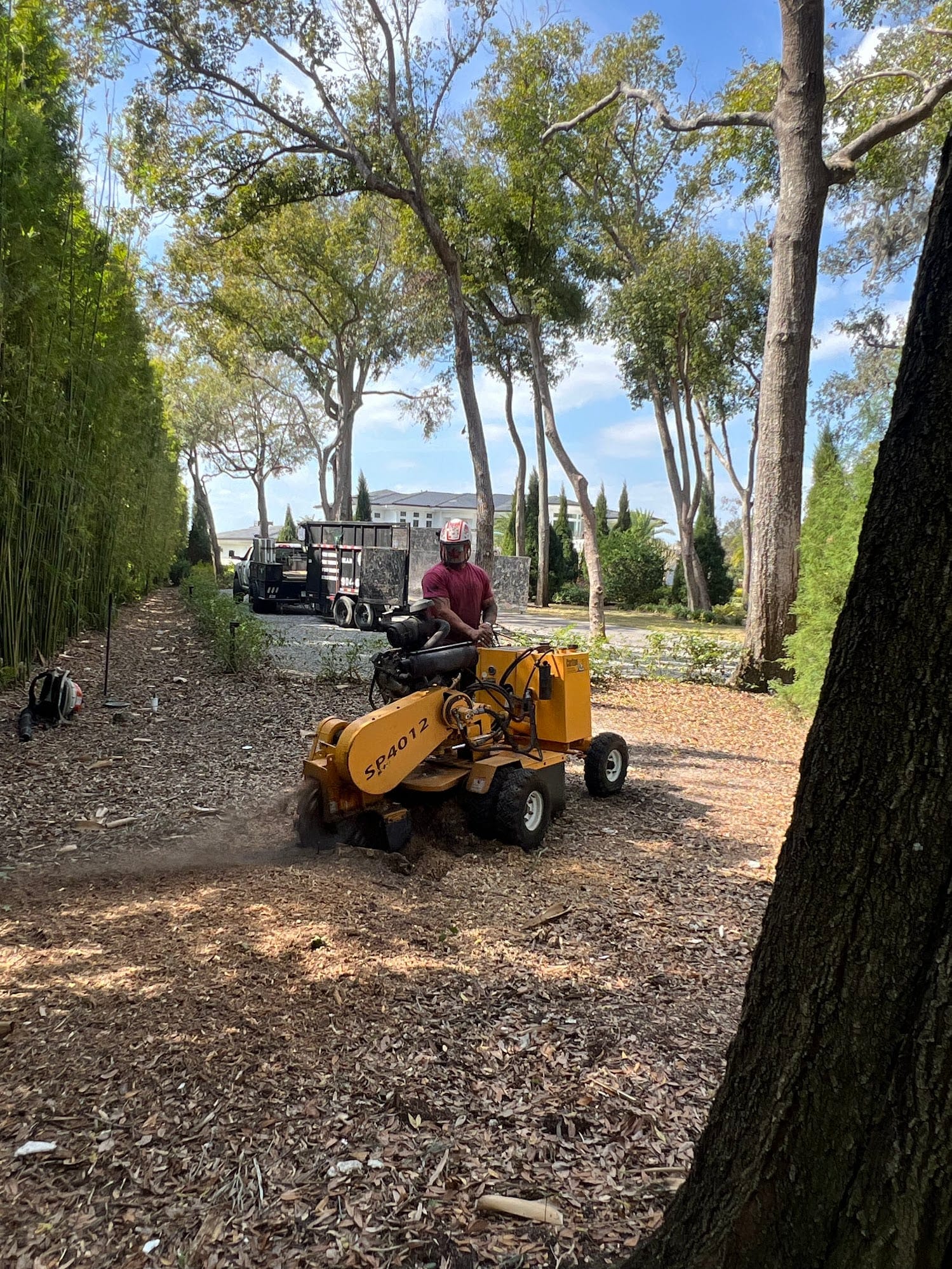 T.E.A.M. crew member operating a stump grinder at a residential property